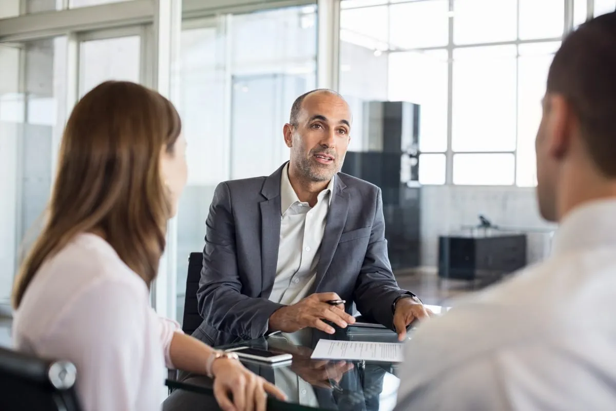 Adviser meeting with clients across a desk