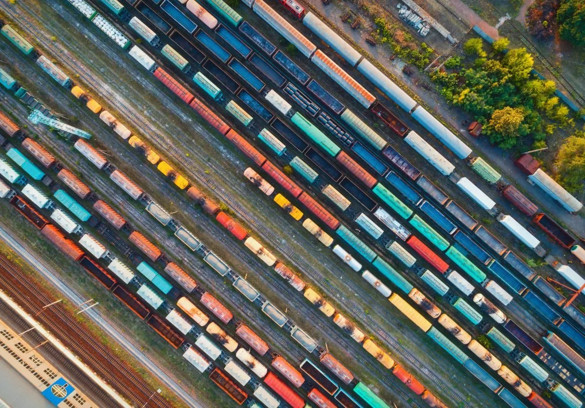 Aerial view of rows of colourful cargo trains in a rail yard