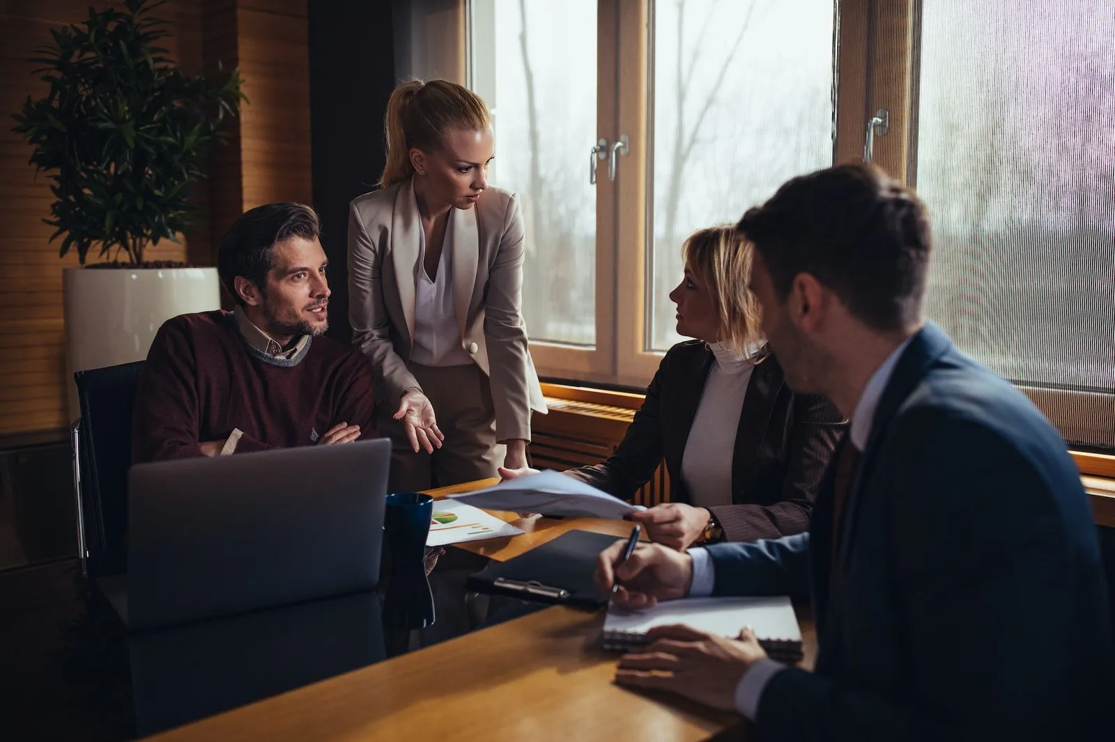 Colleagues in a meeting discussing work on a laptop