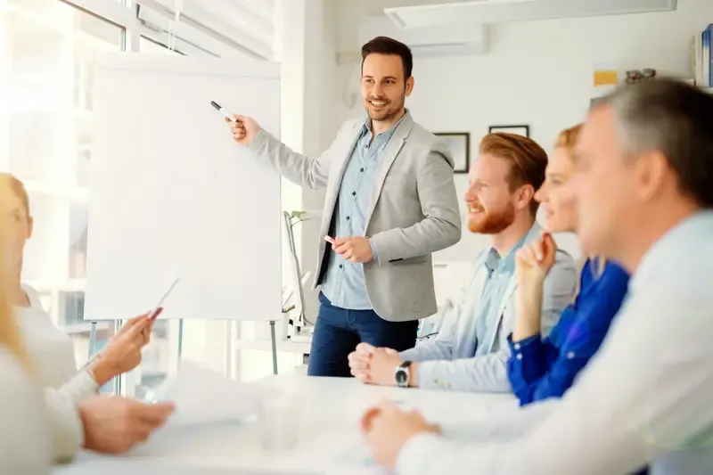 Man presenting at a flipchart to his team