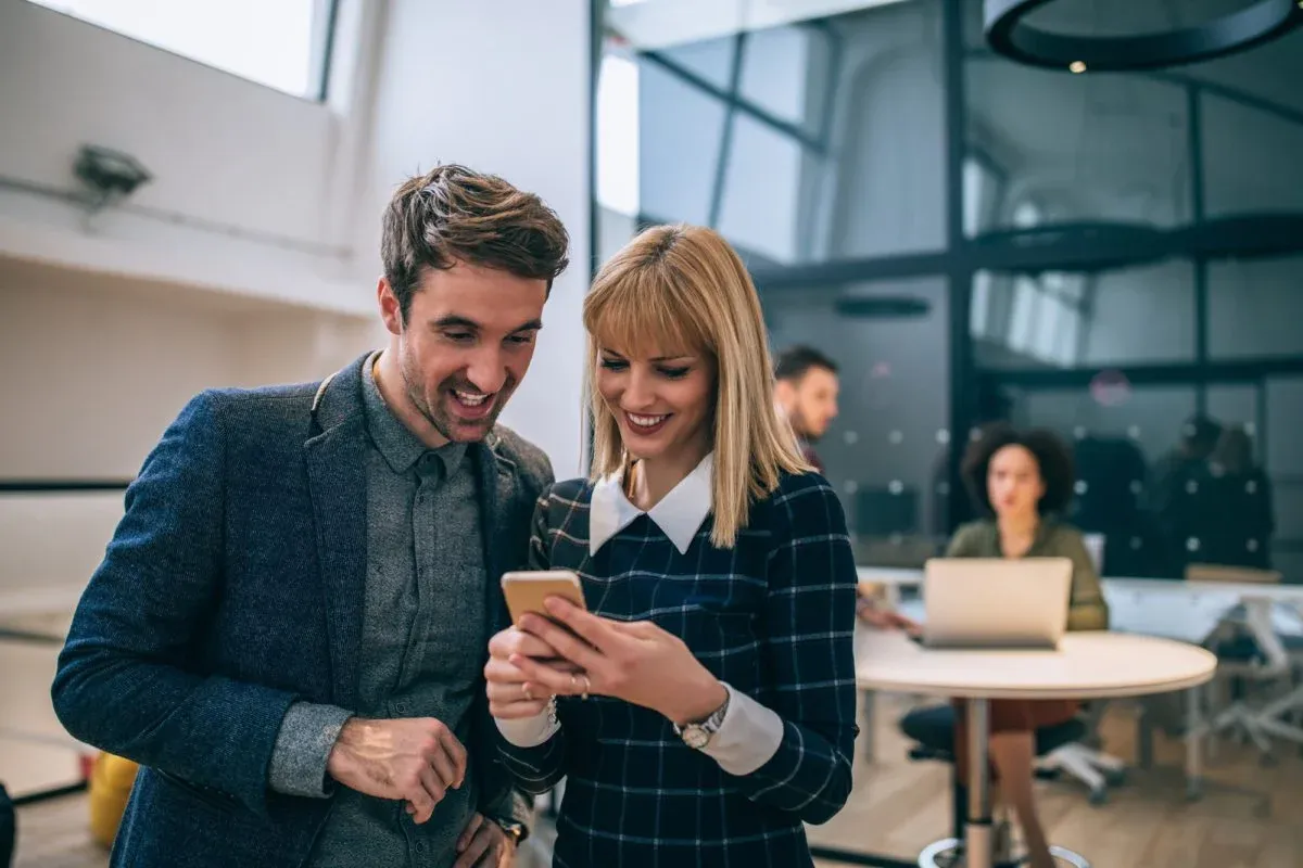 Two colleagues looking at a phone together