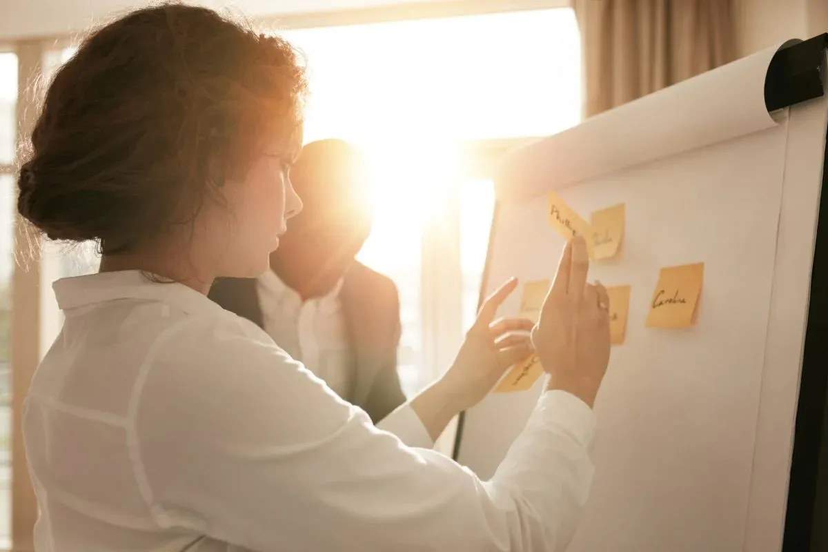 Woman placing sticky notes on a planning wall