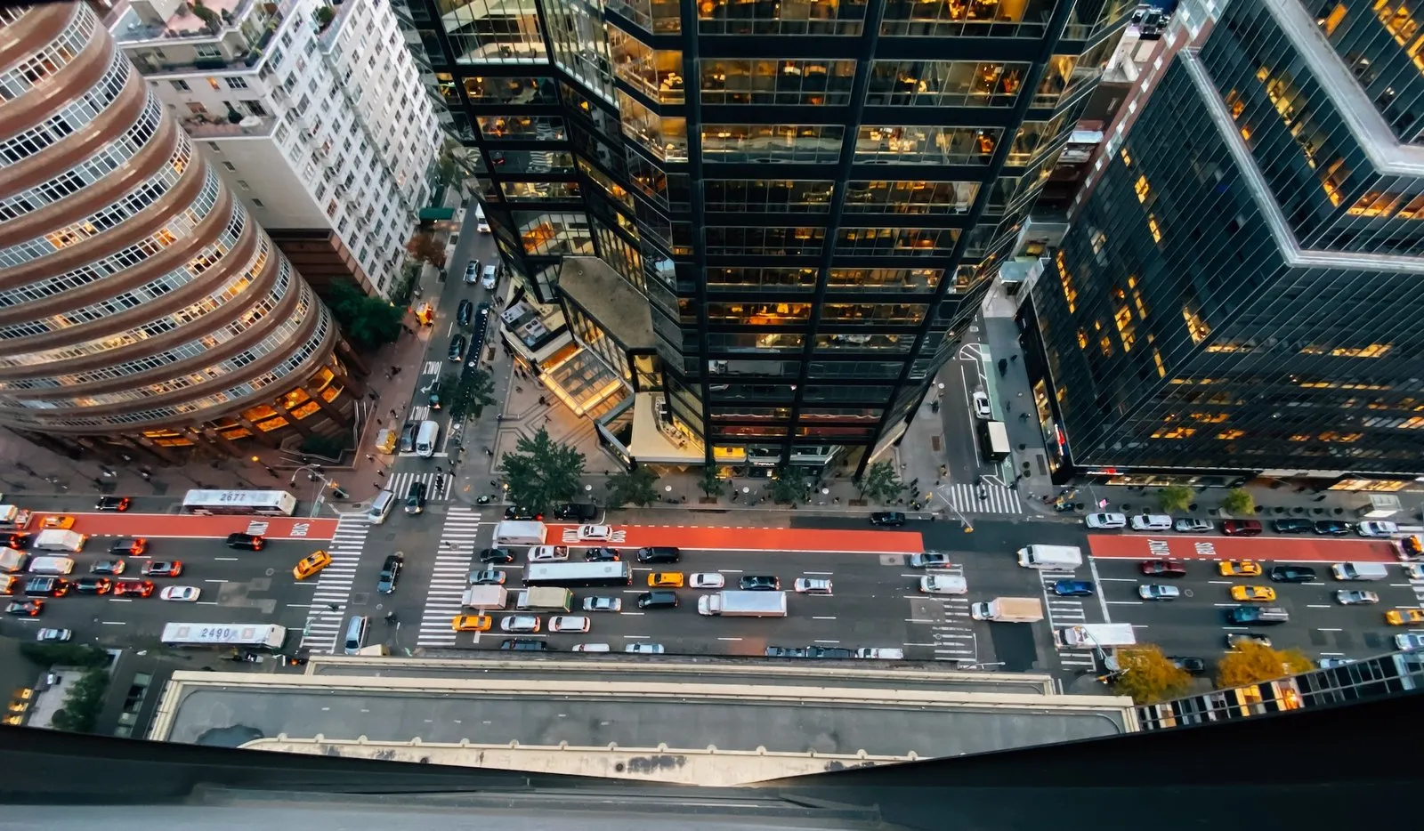 Looking down on a busy city street full of people and traffic
