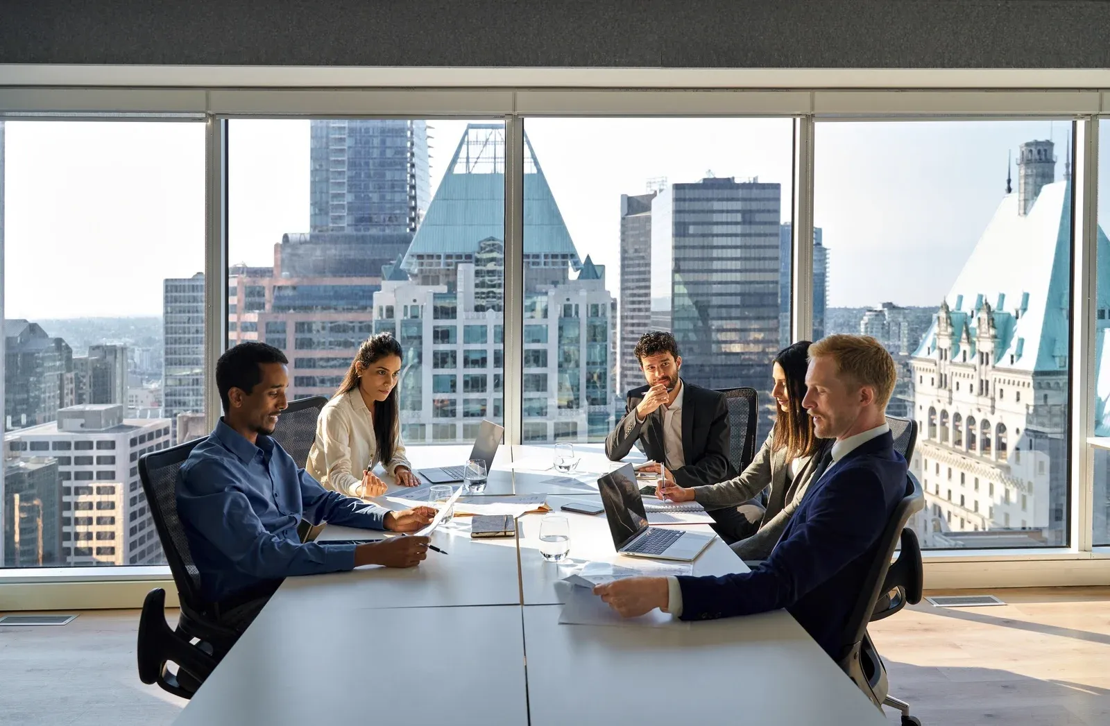 A team meeting in a boardroom with city views
