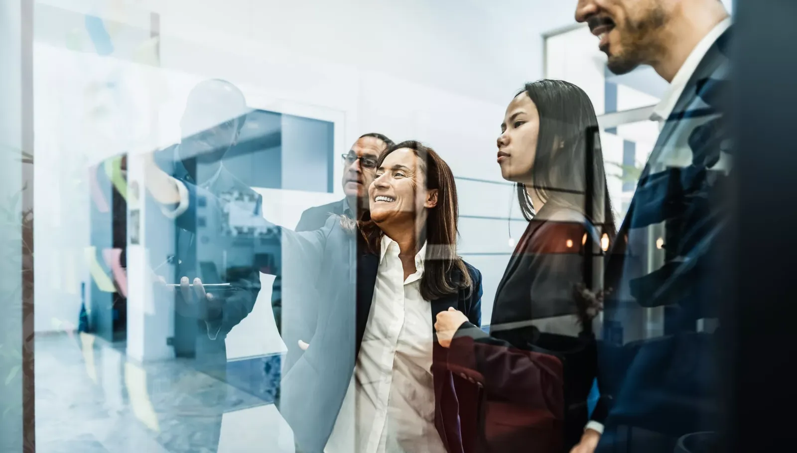 Colleagues talking in a glass-walled meeting room