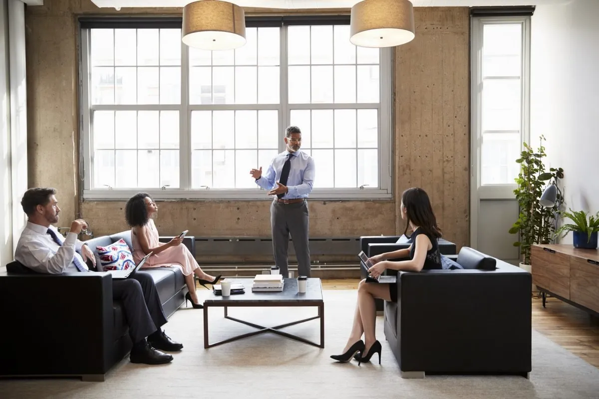 Manager presenting to colleagues in an open-plan lounge