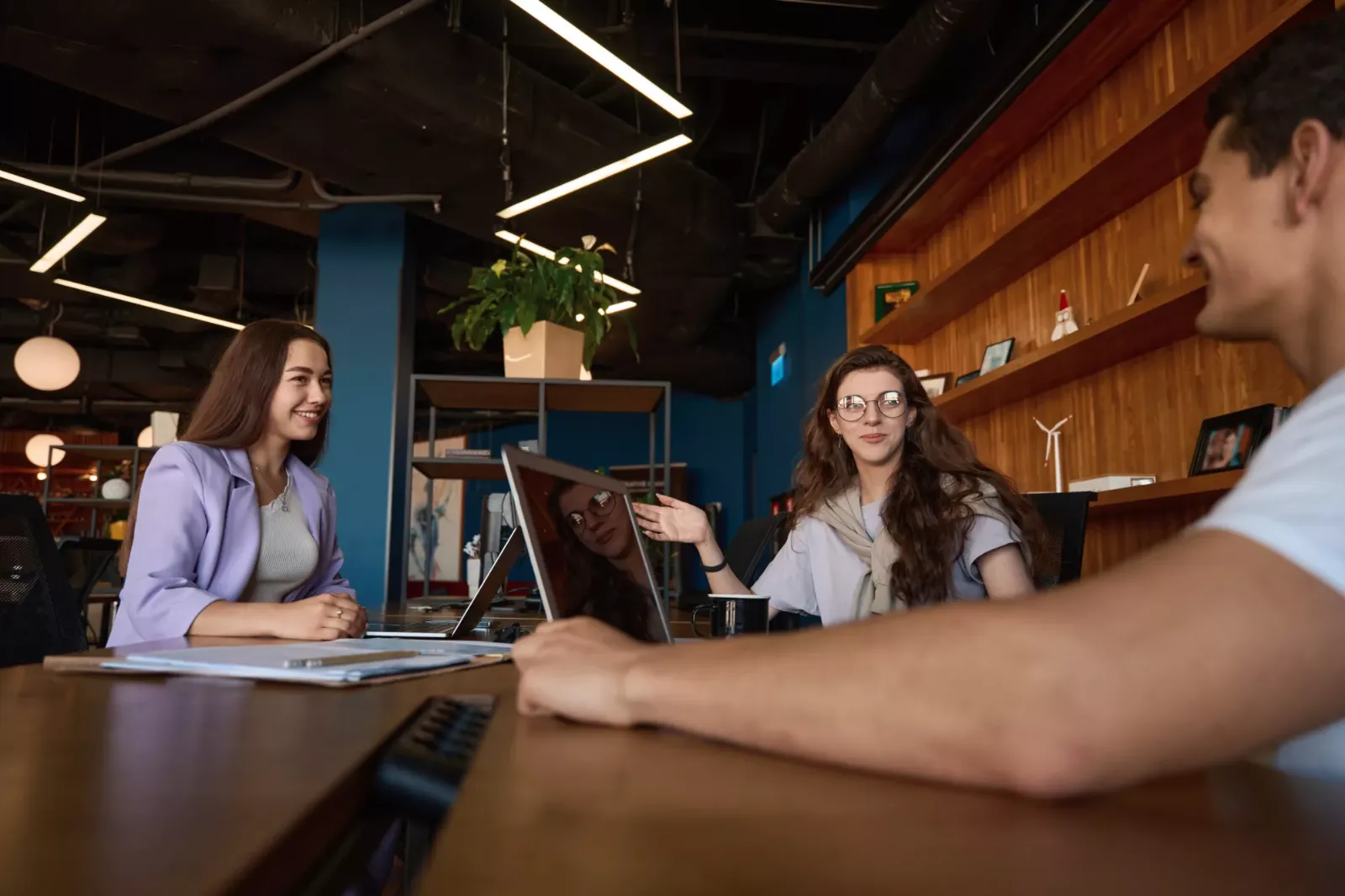 Team talking around a table in a warm, busy office