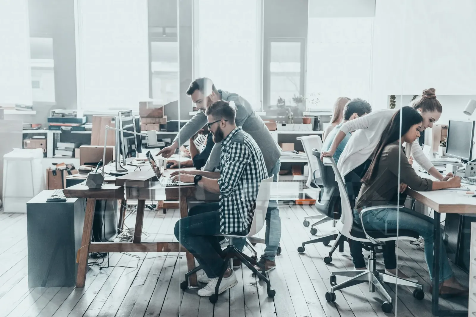 People working at desks in a large open-plan office