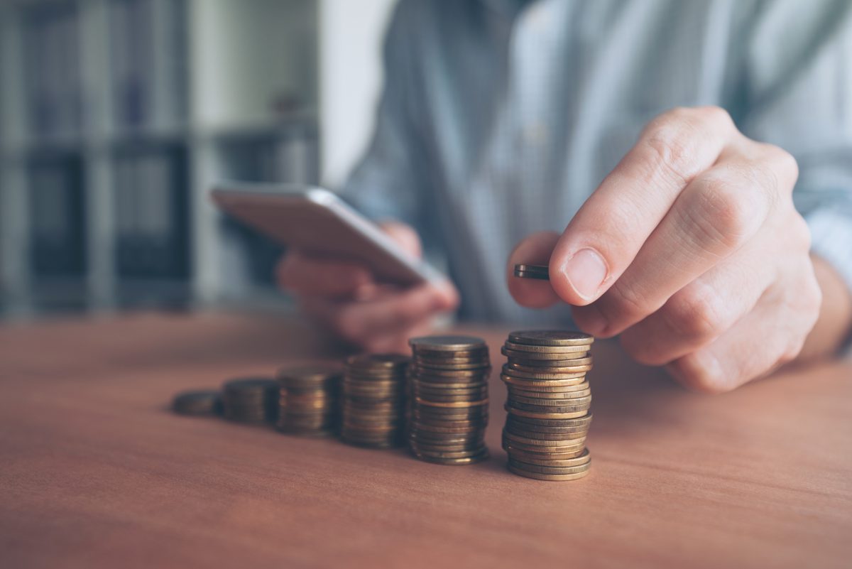 Hand stacking coins into columns
