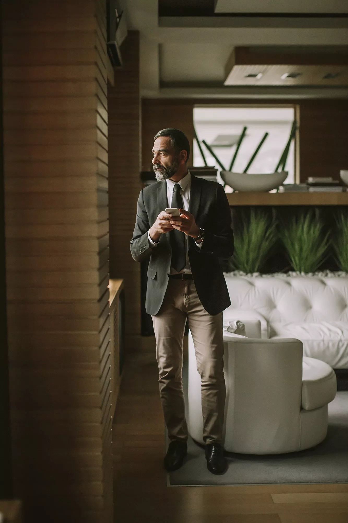 Portrait of senior businessman using cell phone in modern office