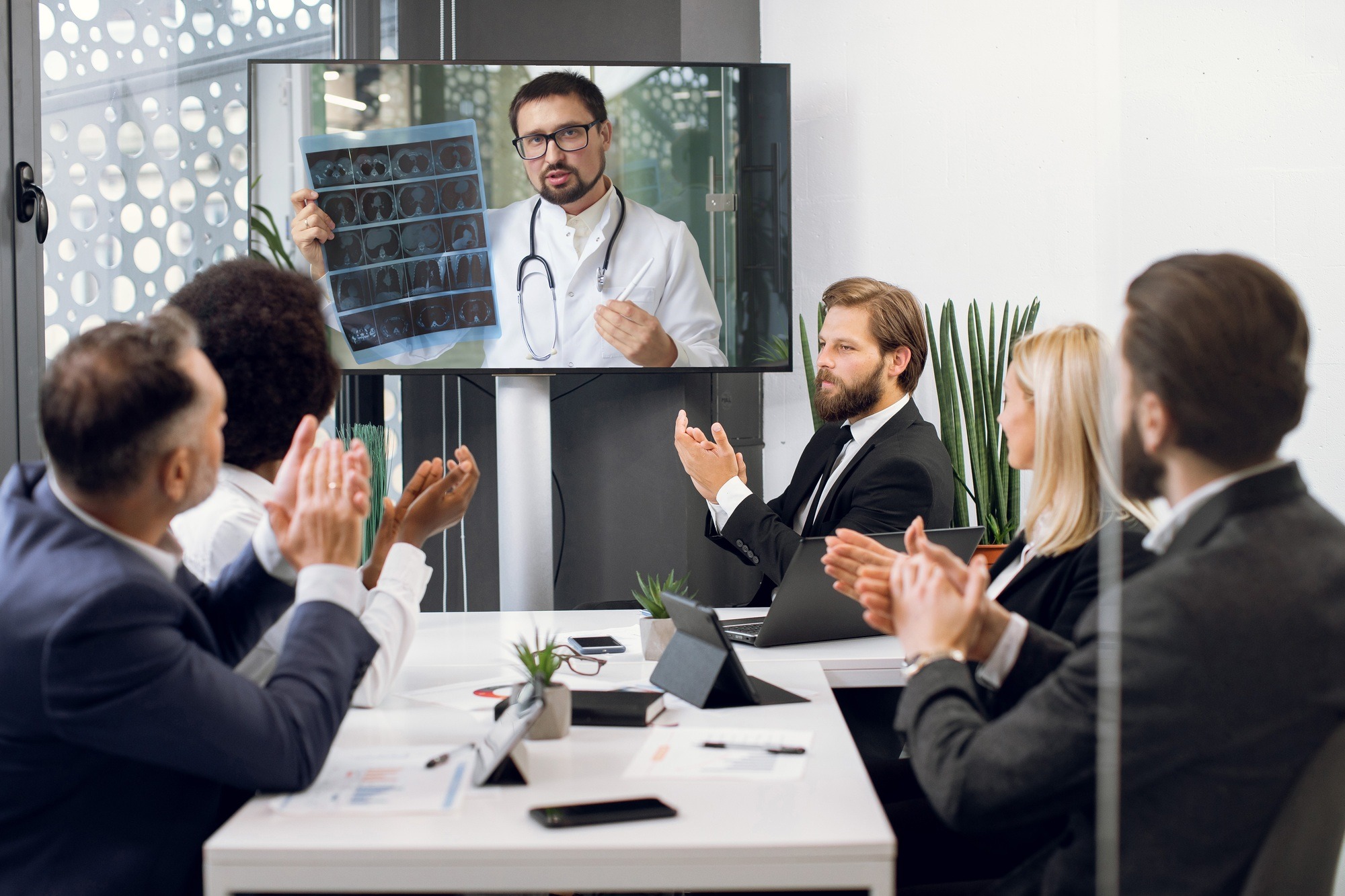 Front view of five multiracial business people, healthcare experts, discussing cost efficiency of