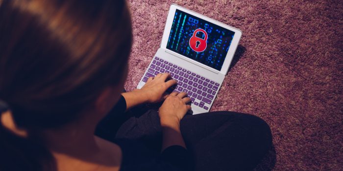 Female woman typing on locked smart device pad attacked by ransomware virus