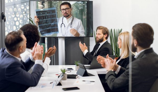 Front view of five multiracial business people, healthcare experts, discussing cost efficiency of