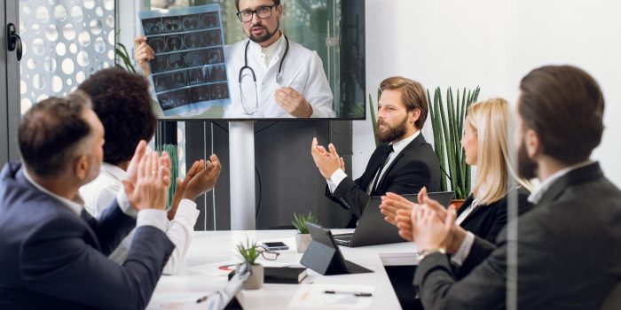 Front view of five multiracial business people, healthcare experts, discussing cost efficiency of