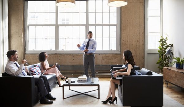 Male manager presenting at informal meeting in a lounge room