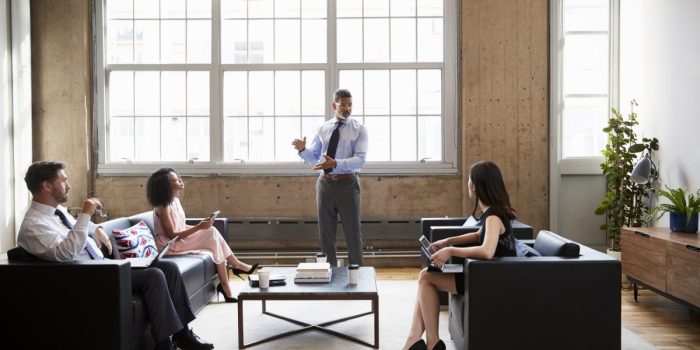 Male manager presenting at informal meeting in a lounge room