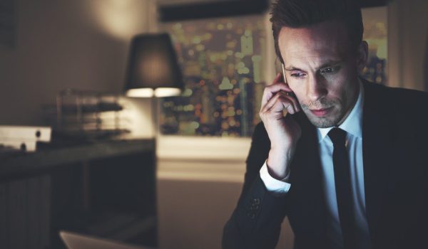 The finance adviser with phone browsing laptop