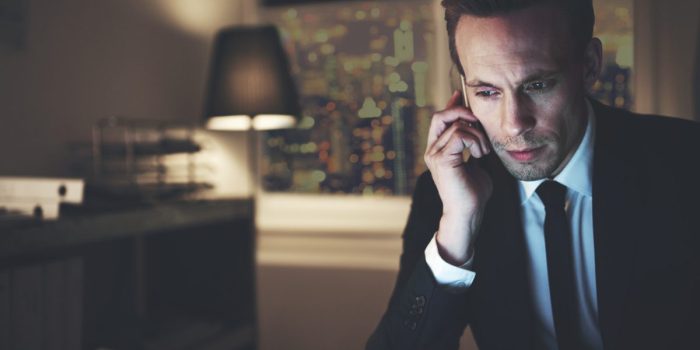 The finance adviser with phone browsing laptop